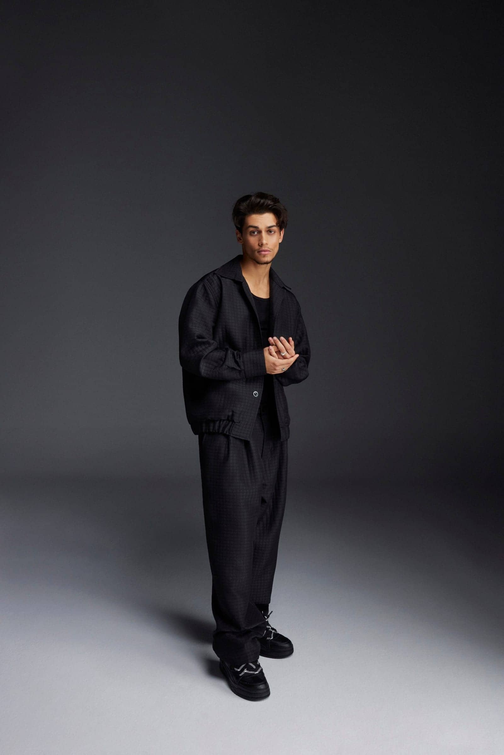 Full-length portrait of Harris J in a black quilted suit